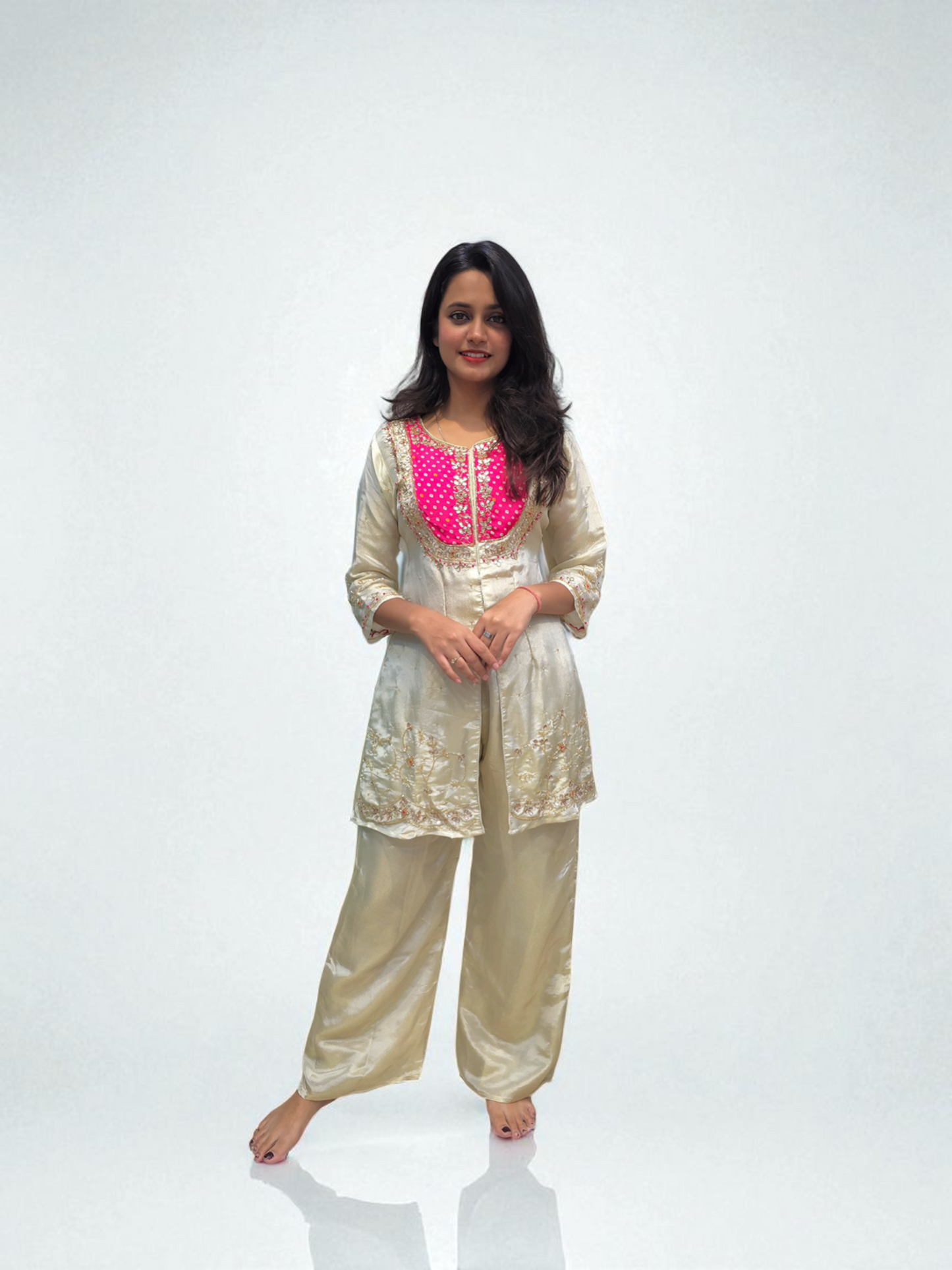 Woman wearing a traditional outfit with a pink embroidered top on a white background