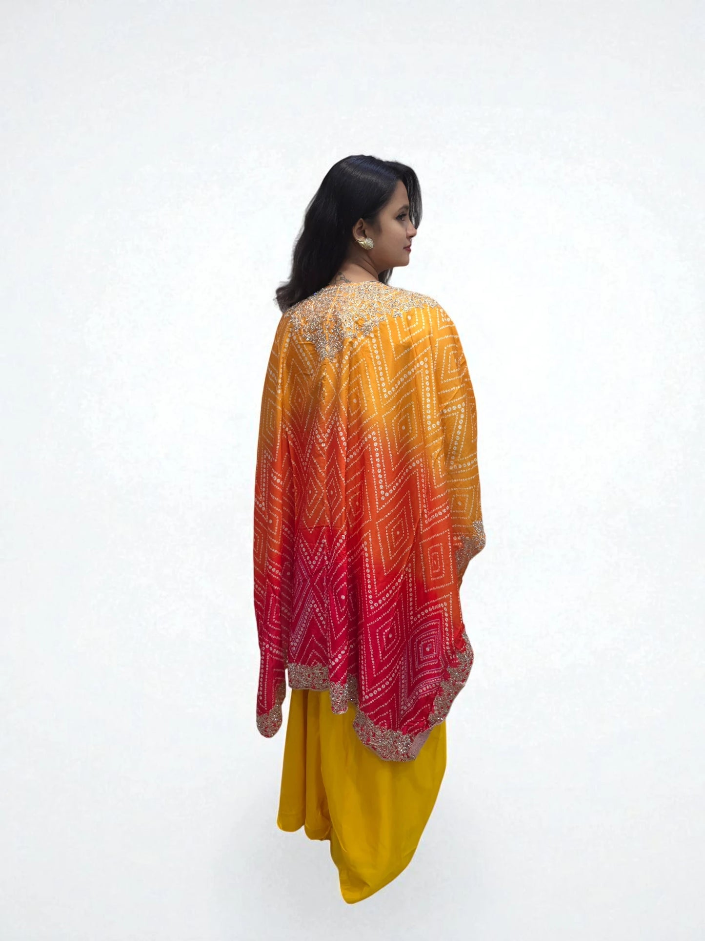 Back view of ombre orange pink bandhani cape styled with yellow dhoti skirt
