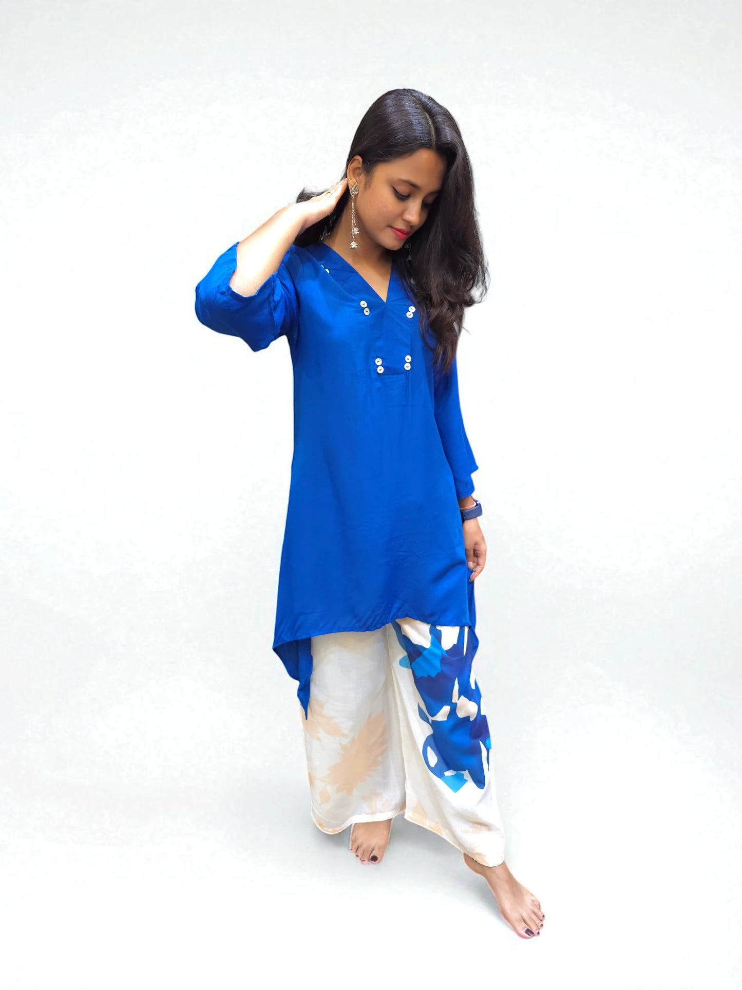 Stylish women’s co-ord set with asymmetrical C-cut blue top and contrast white printed trousers.