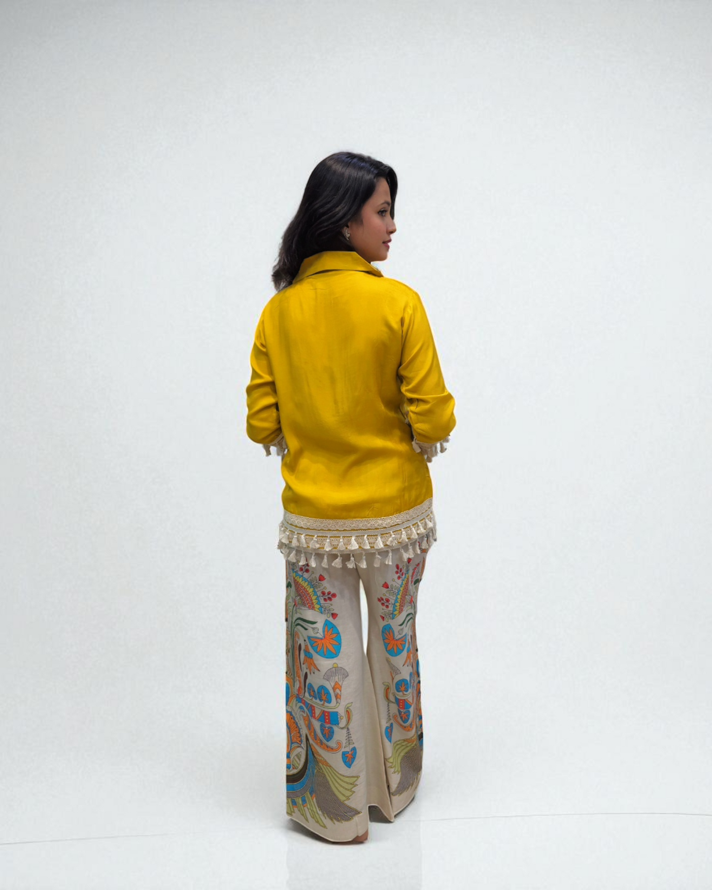 Person wearing a yellow jacket and patterned pants on a white background