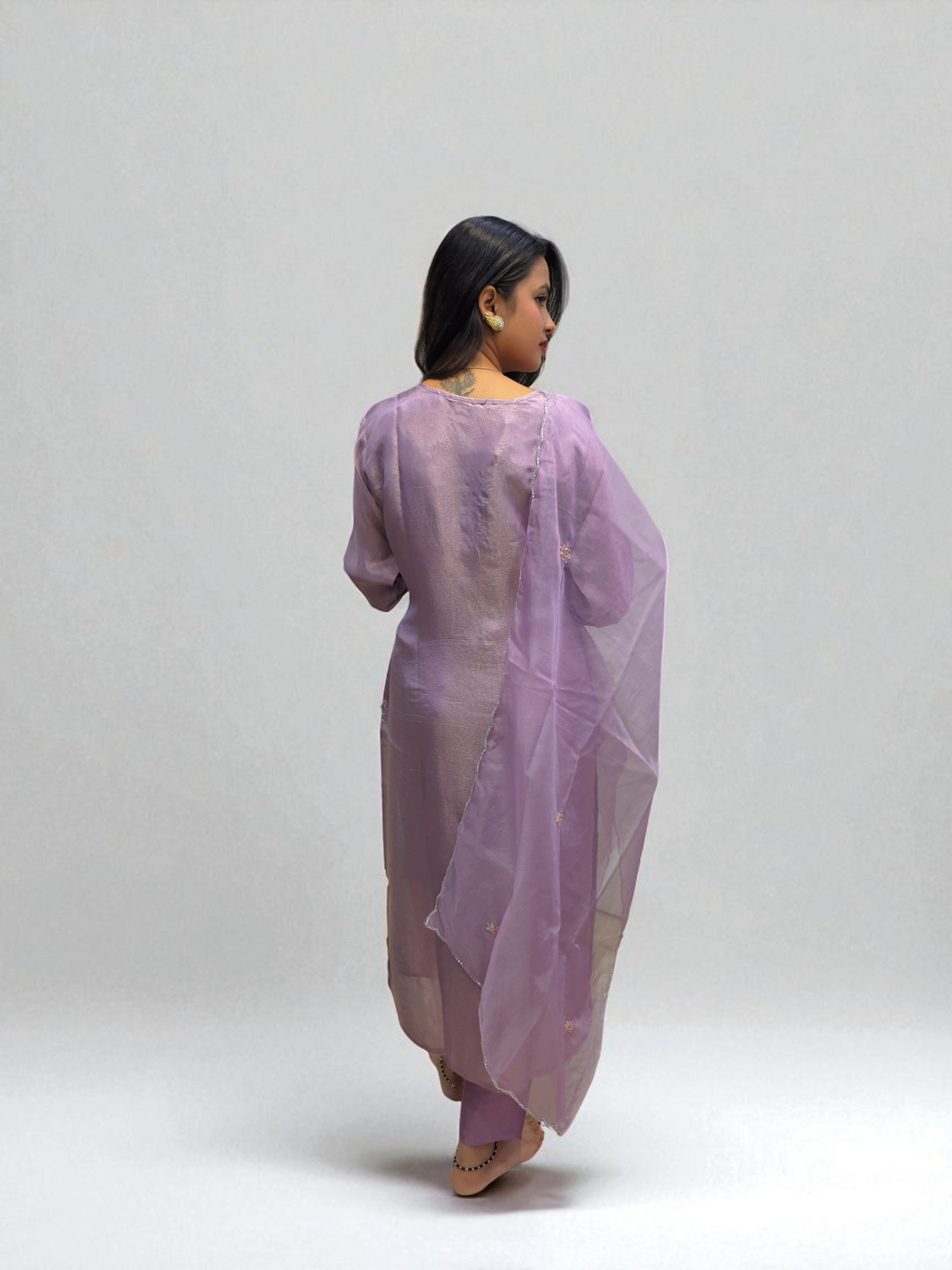 Elegant woman in a lavender kurta set with organza dupatta, showcasing traditional handwork and style from Ambika Boutique.