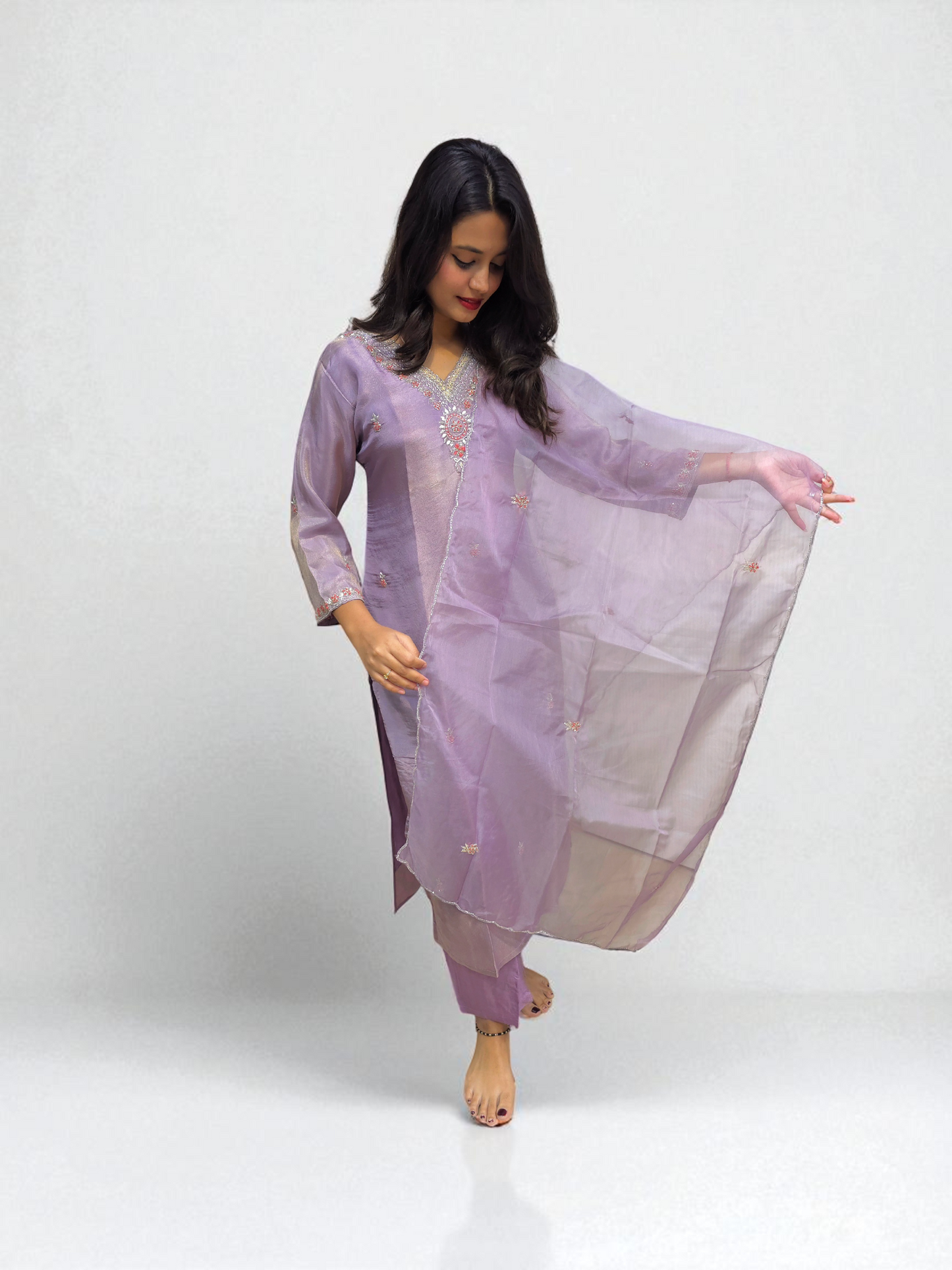 Elegant woman wearing a lavender pure shimmer tissue kurta set with handwork, showcasing traditional style for special occasions.