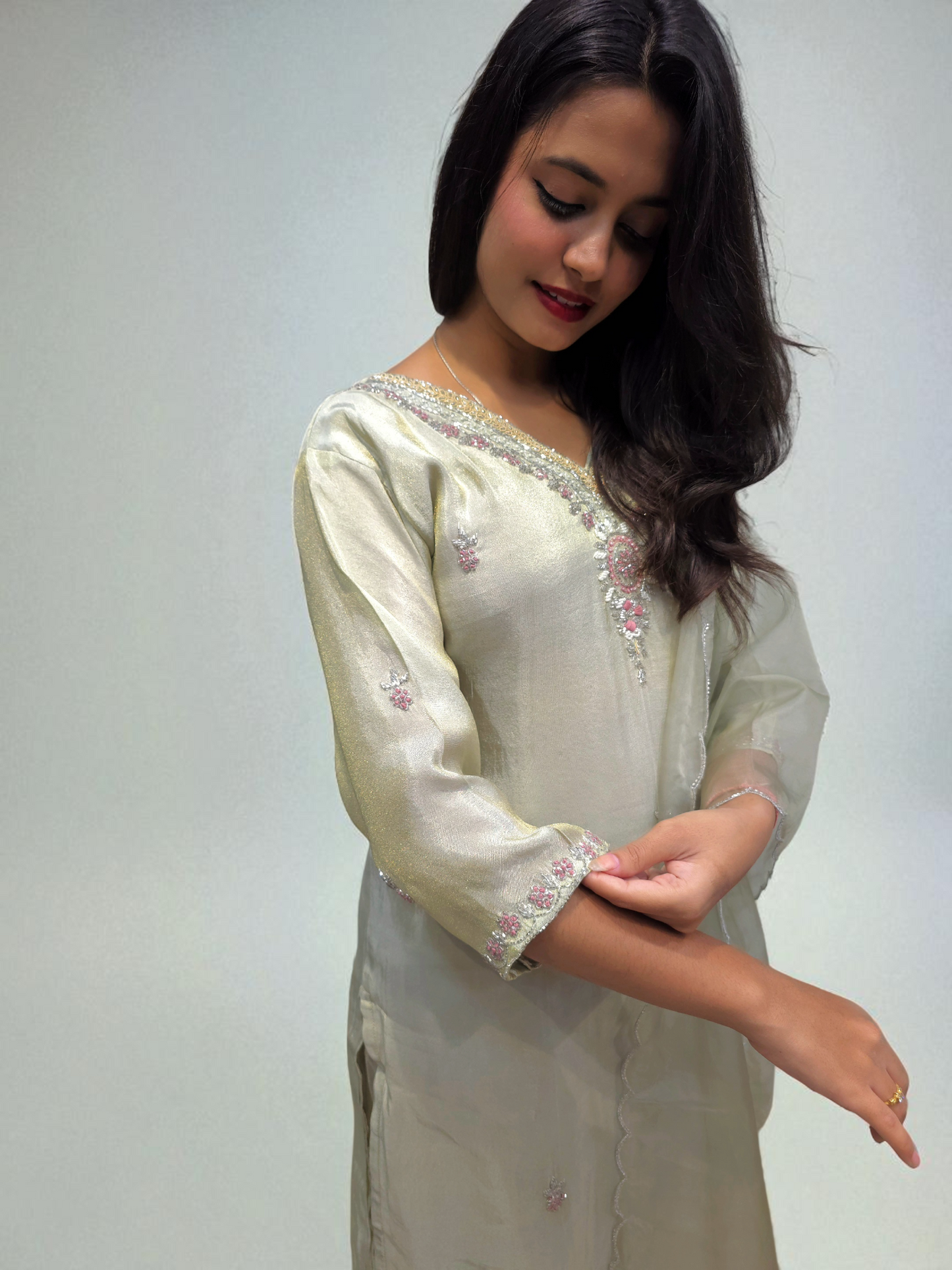 Elegant woman in a ivory kurta set with handwork and organza dupatta, perfect for party wear from Ambika Boutique.