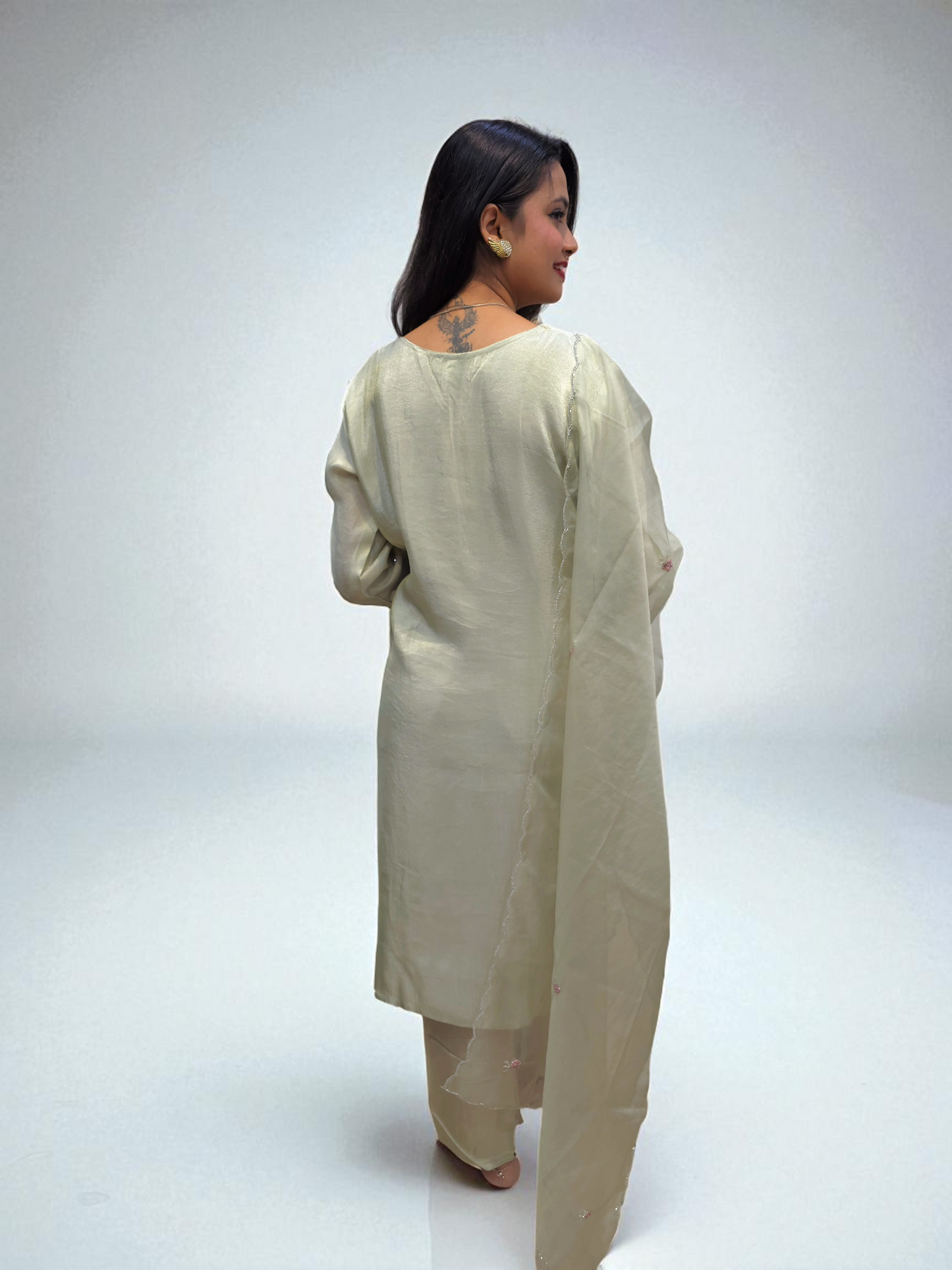 back view Elegant woman in a ivory kurta set with organza dupatta, showcasing traditional handwork and style from Ambika Boutique.