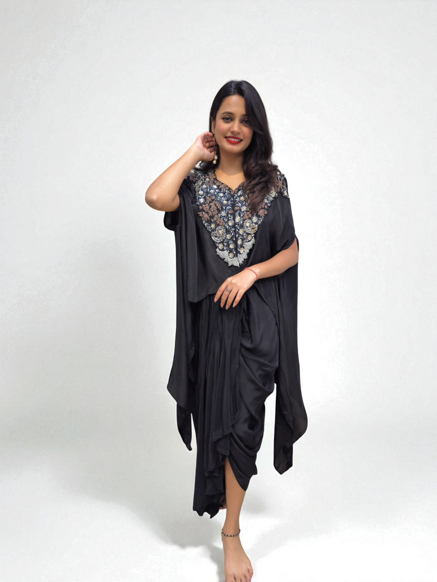 Woman wearing Designer Black Cape Dhoti Skirt Set with Hand Embroidery for festive occasions by Ambika Boutique.