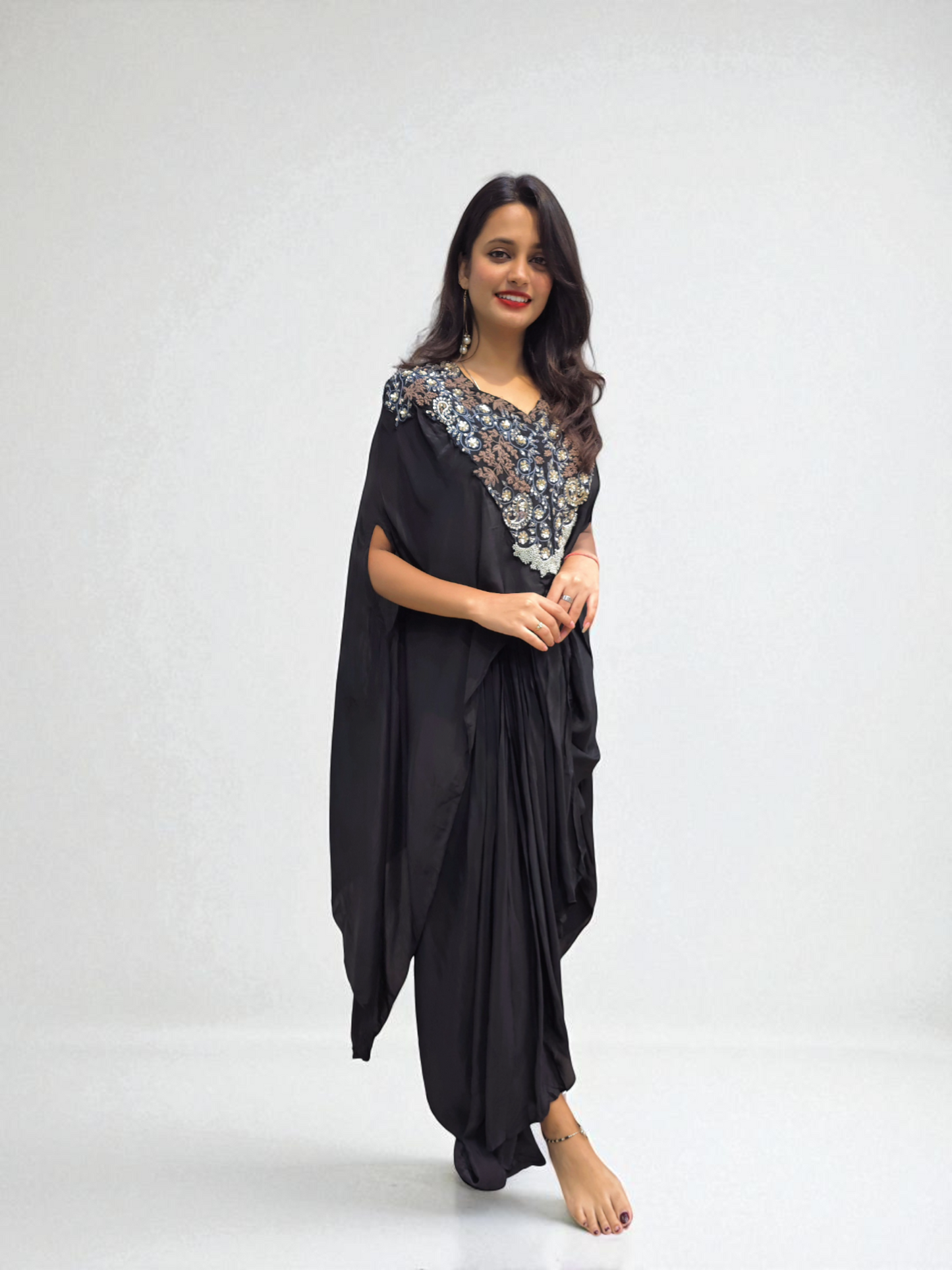 Woman wearing a Designer Black Cape Dhoti Skirt Set with Hand Embroidery by Ambika Boutique, ideal for festive occasions.