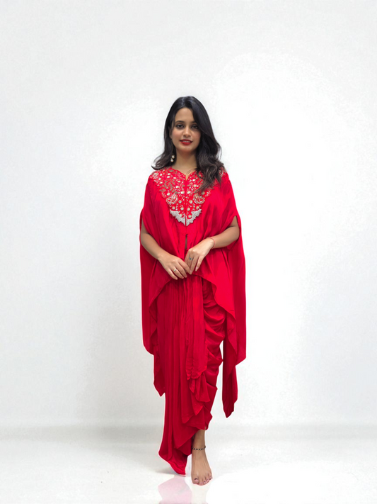Woman wearing Designer Red Cape Dhoti Skirt Set with Hand Embroidery – Festive Outfit by Ambika Boutique.