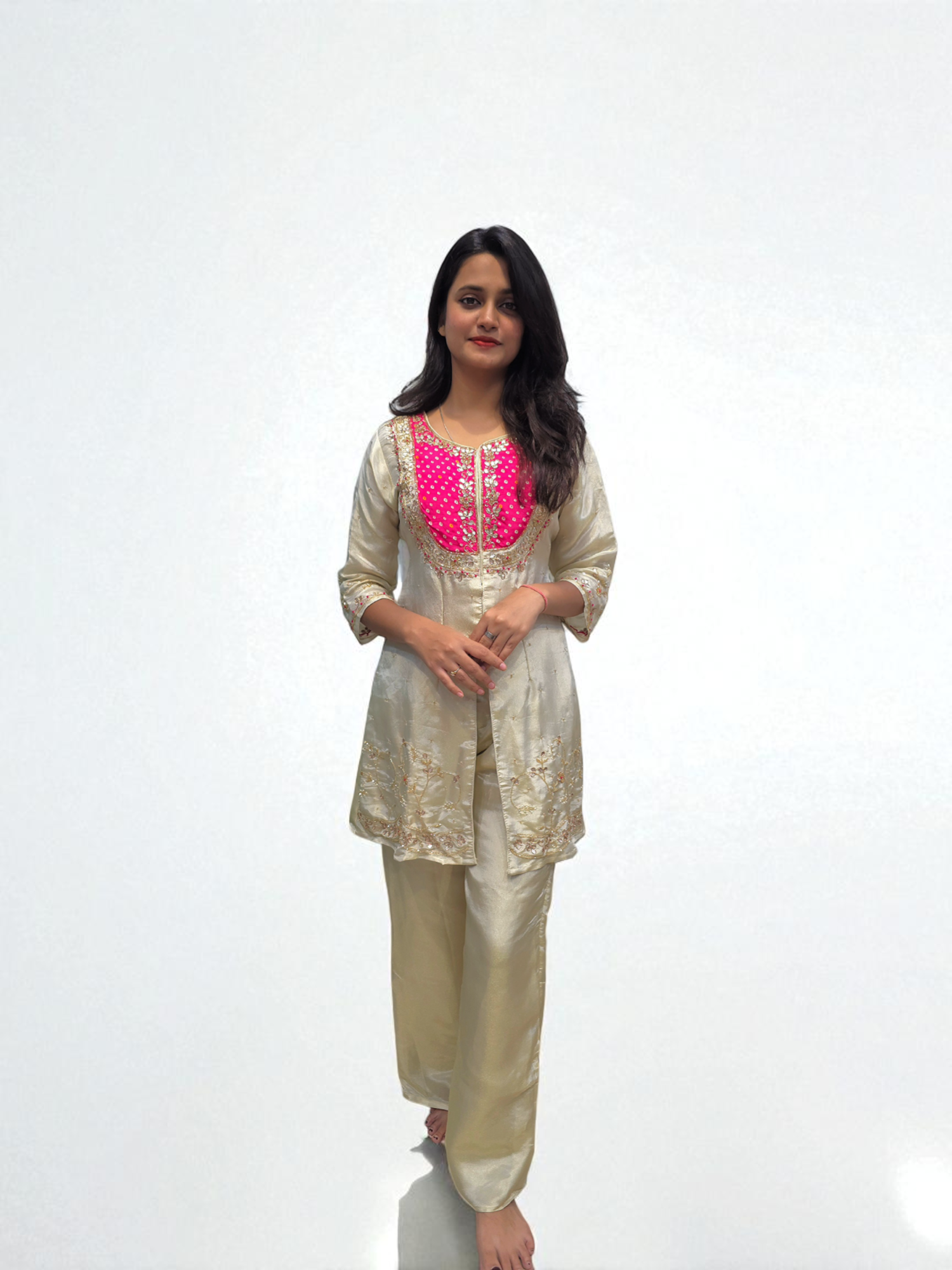 Woman wearing a beige kurta with pink embroidery on a white background