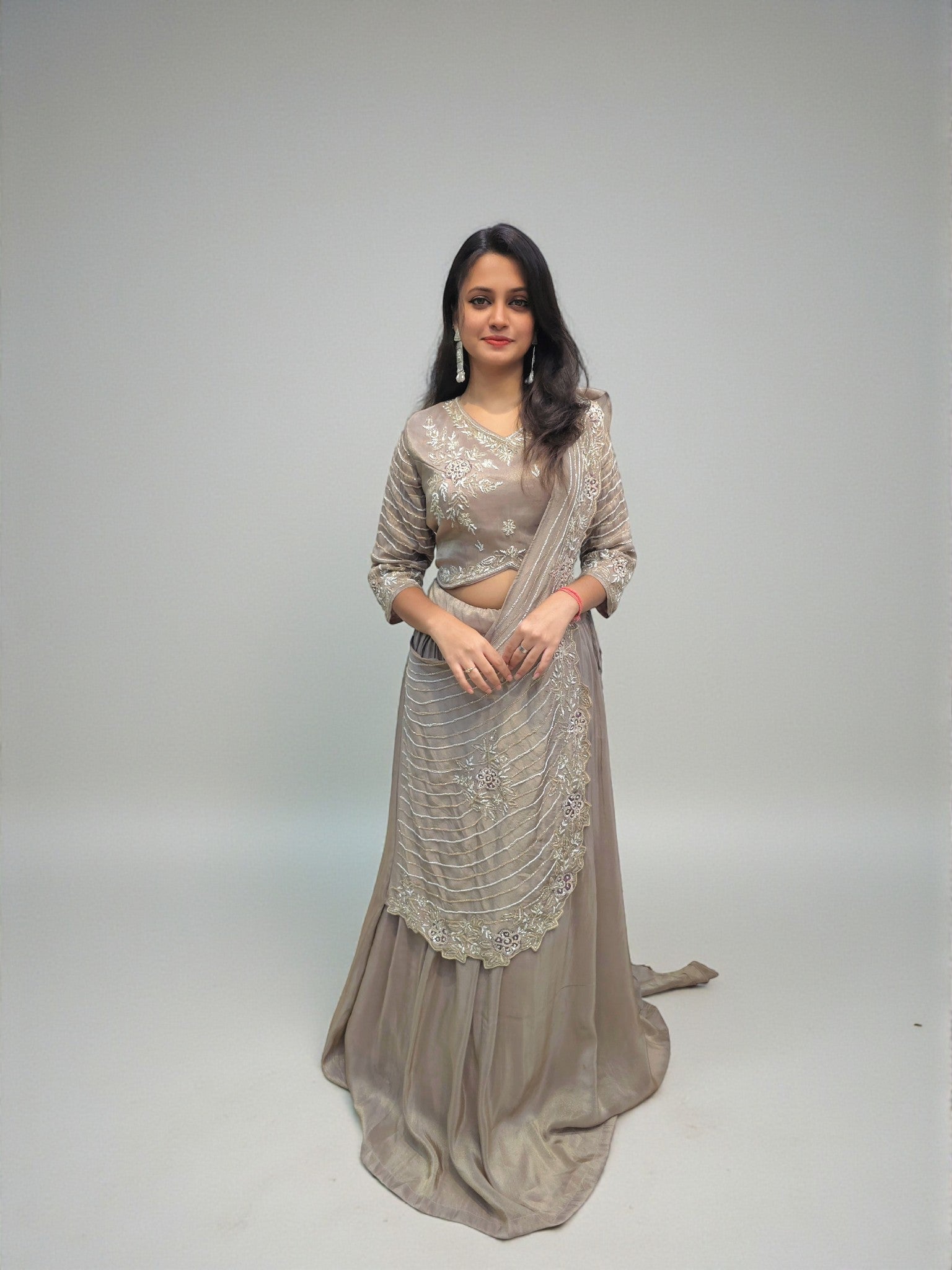 Woman wearing heavy handwork crop top lehenga with drape dupatta