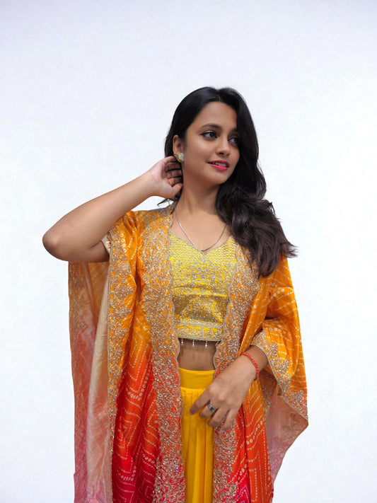 Close-up of yellow heavy embroidered blouse with ombre bandhani cape in orange and pnki