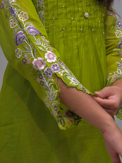 Green embroidered garment with floral patterns on a plain background