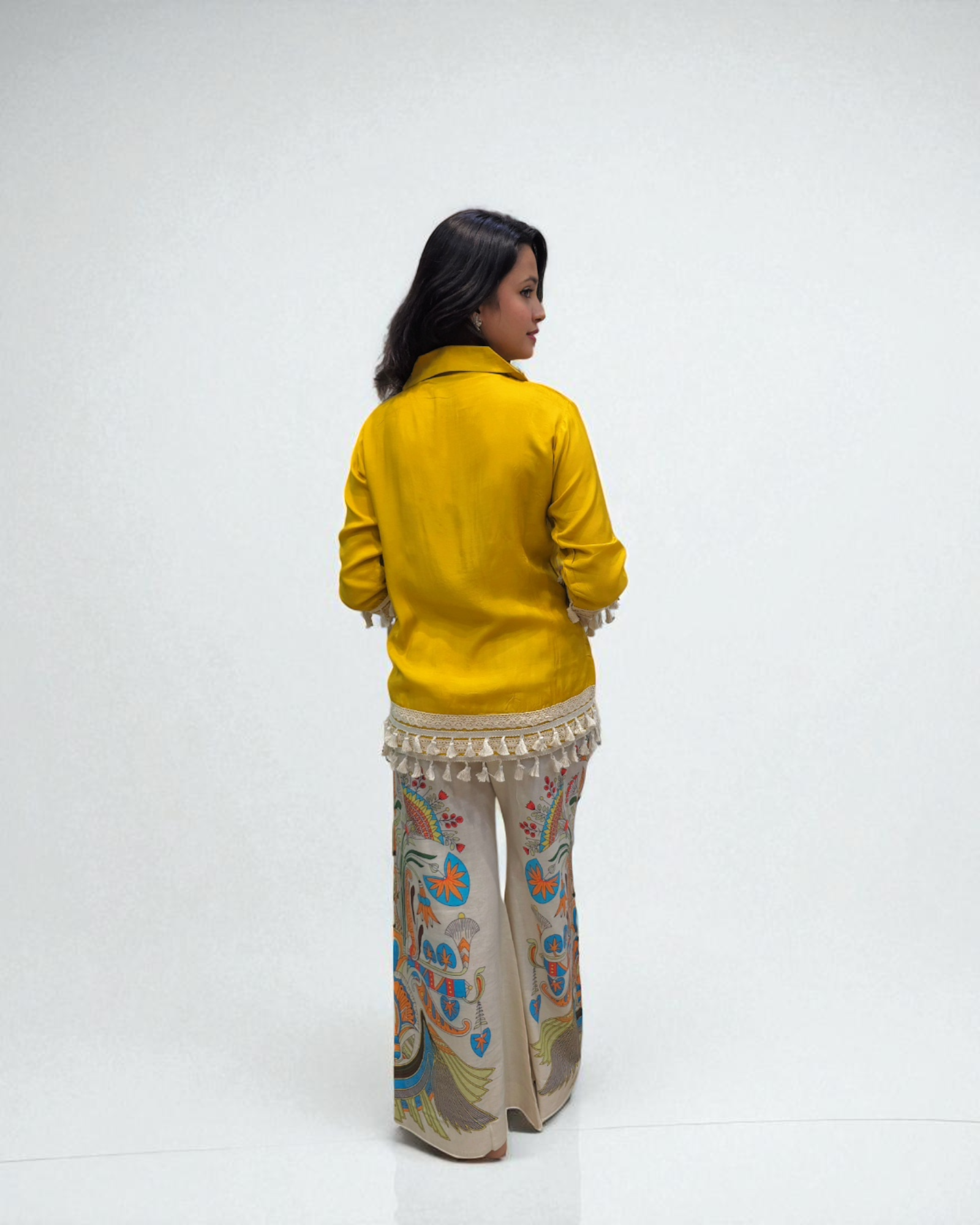 Person wearing a yellow jacket and patterned pants on a white background