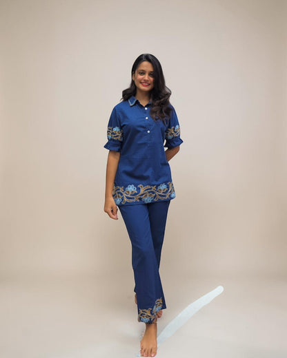 Woman wearing a blue outfit with embroidery on a white background