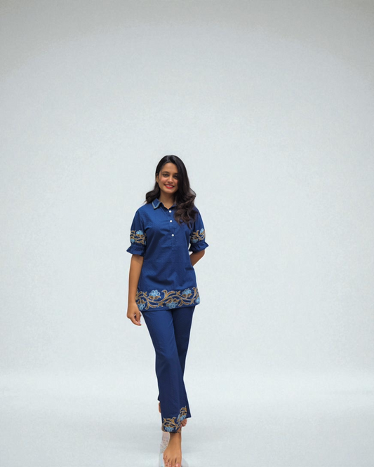 Woman wearing a blue outfit with embroidery on a white background