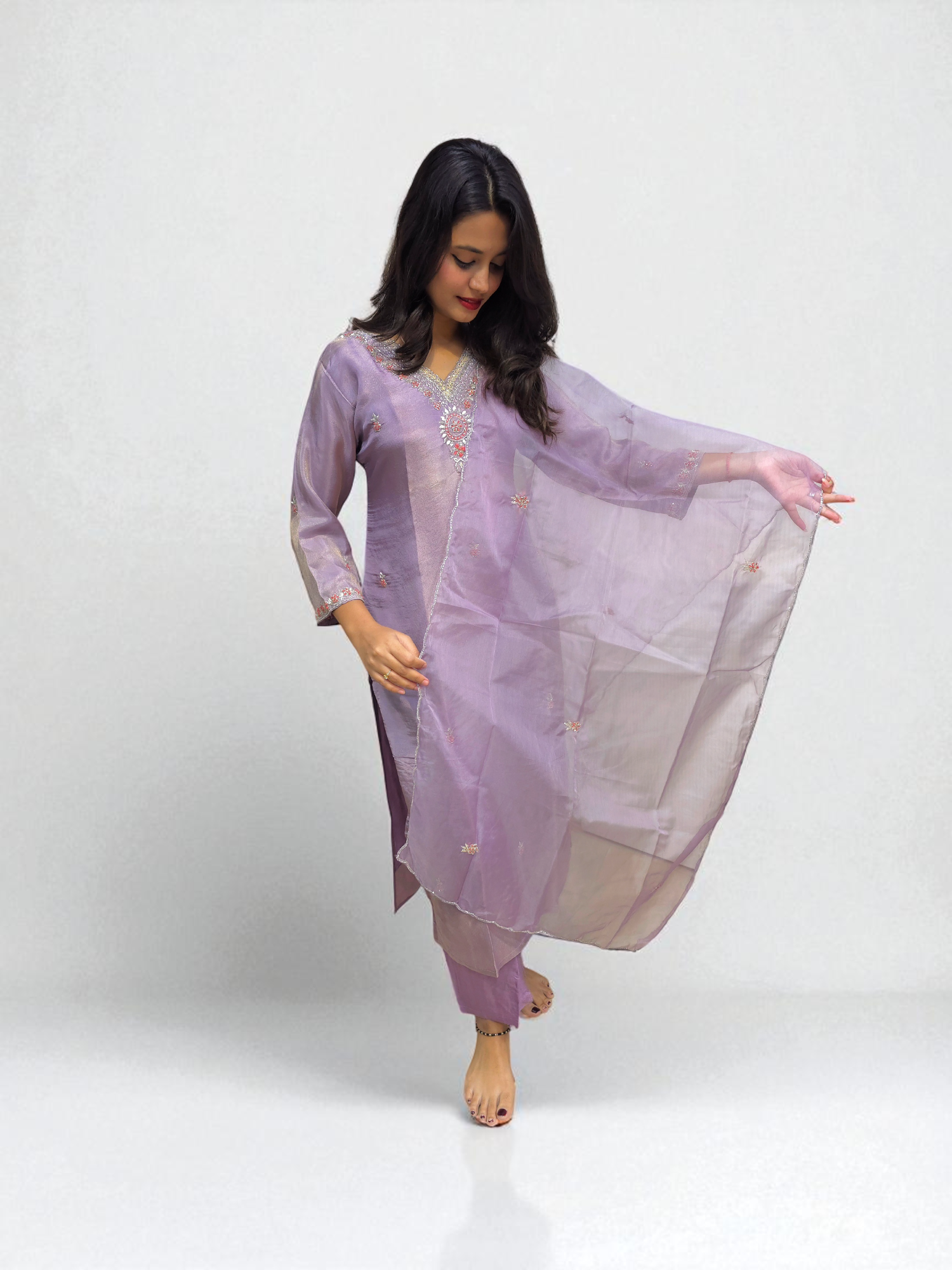 Elegant woman wearing a lavender pure shimmer tissue kurta set with handwork, showcasing traditional style for special occasions.