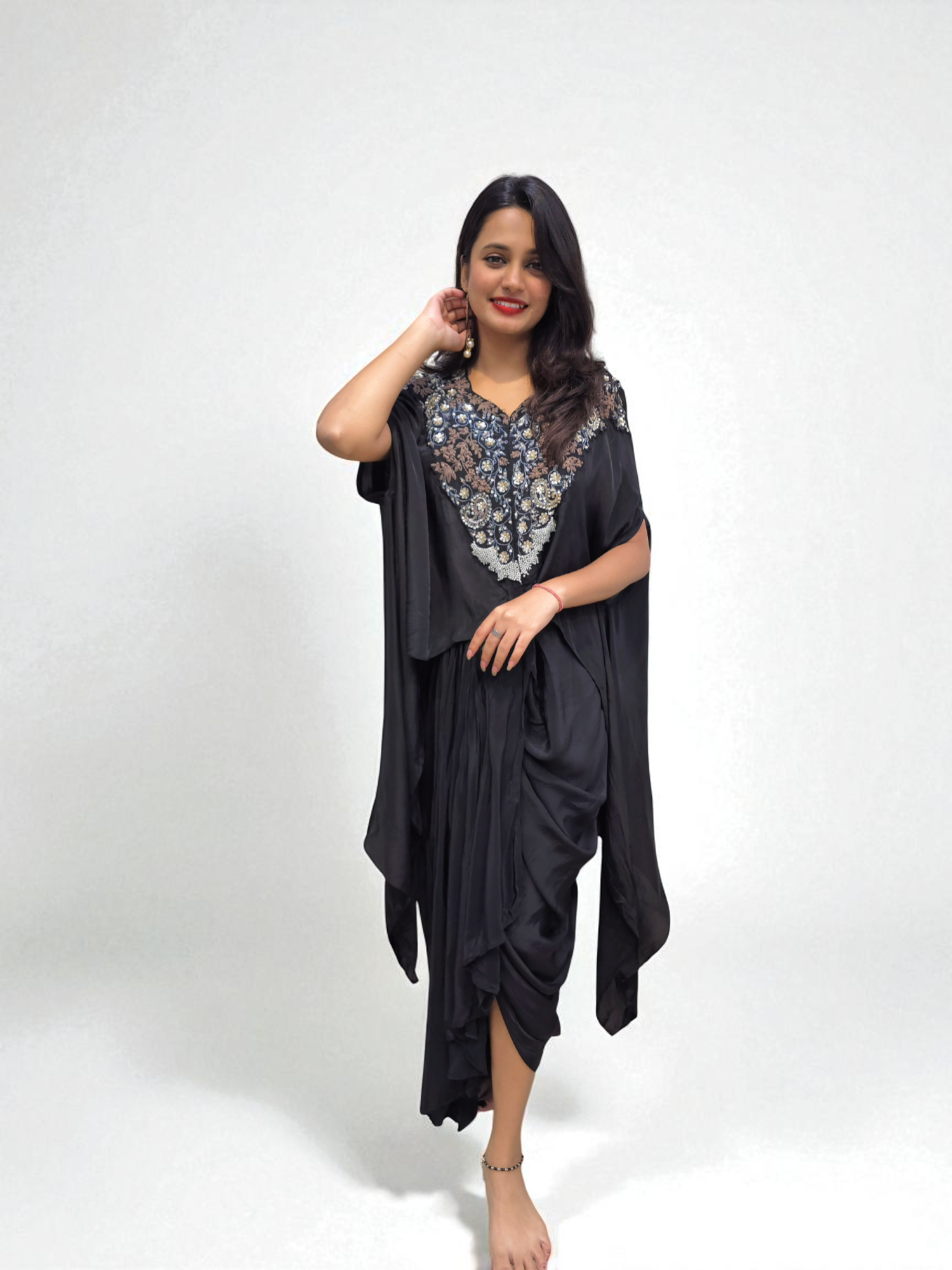 Woman wearing Designer Black Cape Dhoti Skirt Set with Hand Embroidery for festive occasions by Ambika Boutique.
